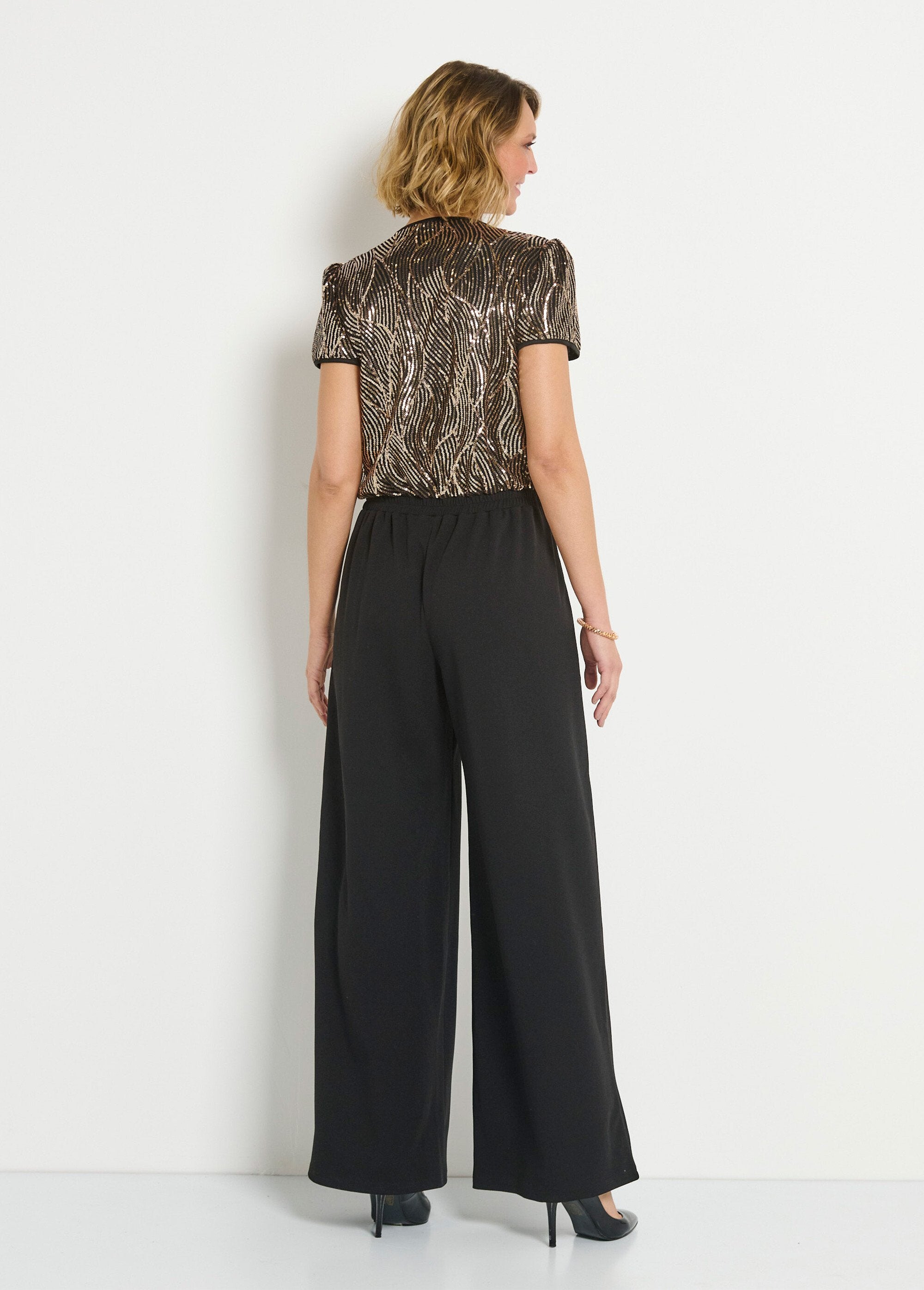 Flowing_jumpsuit_with_sequins_and_heart-shaped_wrap_Black_and_gold_DO1_slim